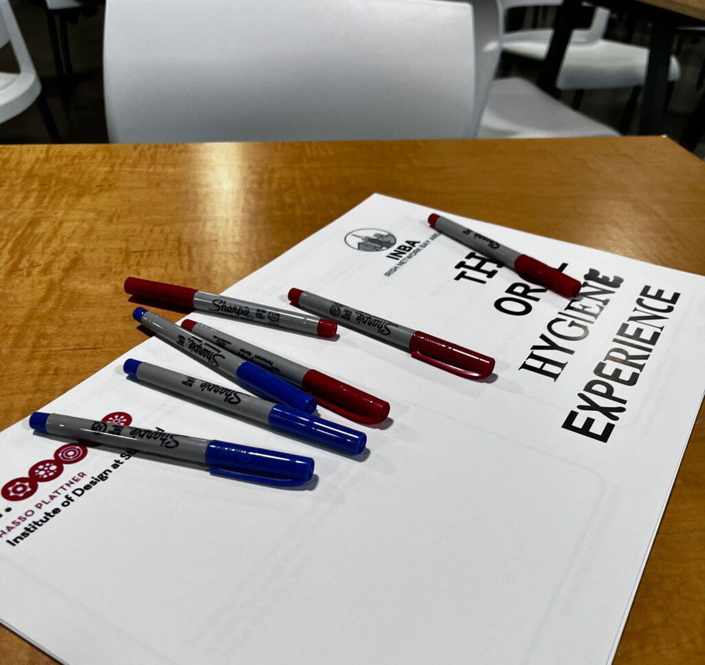 Several black and red pens lie on a paper packet